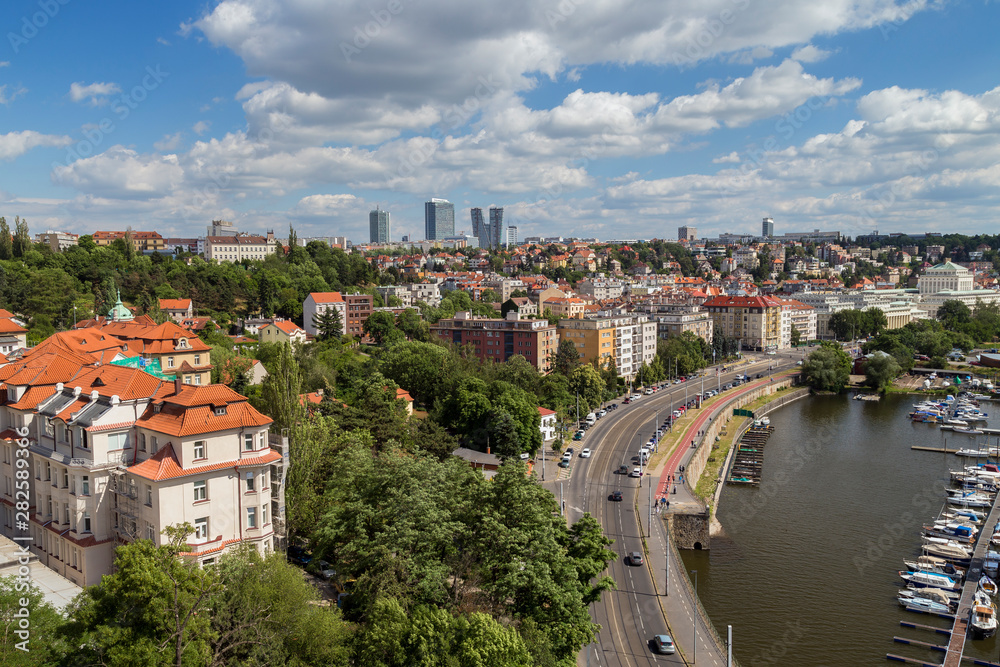 Small dock, boats and city next to the Vltava River in Prague, Czech Republic, viewed from the Vysehrad fort, on a sunny day in the summer.