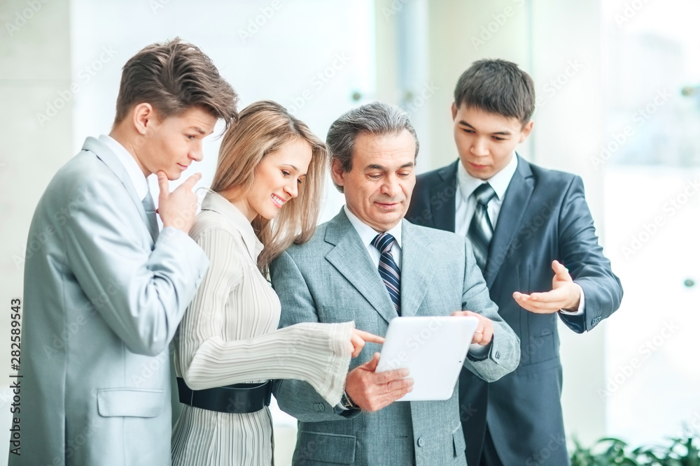 successful business team with tablet and documents discussing business matters successful business team with tablet and documents discussing business matters