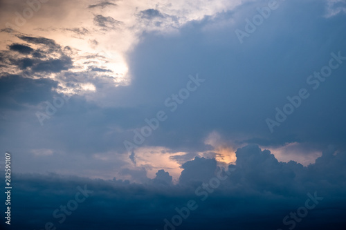 The sun started to shine with orange rays of light in the cloudy sky after the big thunderstorm. © rivermartin