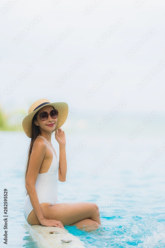 Portrait young asian woman happy smile relax around swimming pool in hotel resort Portrait young asian woman happy smile relax around swimming pool in hotel resort