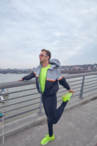 Fototapeta Naklejka Na Ścianę i Meble -  Sportsman working out / jogging on a big city urban bridge.