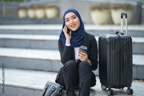 asian hijab woman talking with a friend using smart phone