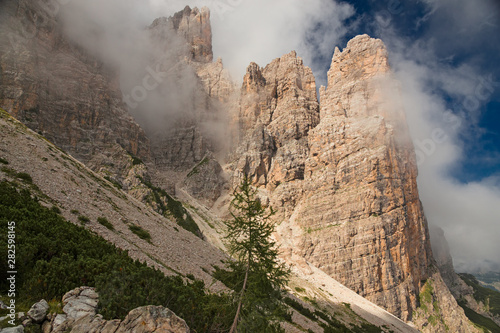 Panoramic view of towers and Dolomite peaks wrapped in clouds