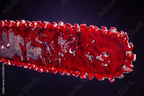detail of a bloody chainsaw. image suitable for horror © tiero
