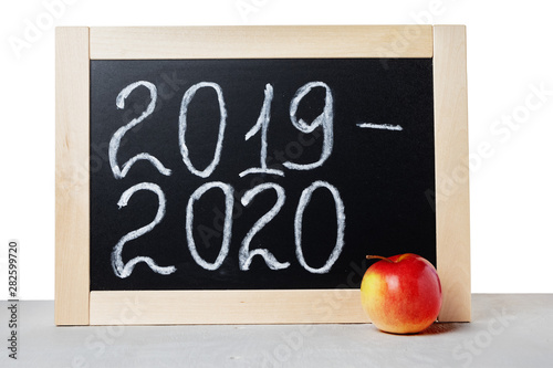 Fototapeta Naklejka Na Ścianę i Meble -  Academic year 2019 2020. Background School blackboard and apple on the table, isolated on white background.