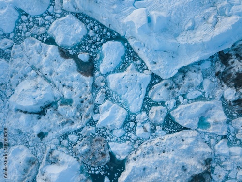 Icebergs drone aerial image top view - Climate Change and Global Warming. Icebergs from melting glacier in icefjord in Ilulissat, Greenland. Arctic nature ice landscape in Unesco World Heritage Site. photo