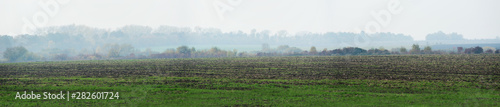 Panoramic view of village from the field, fog, autumn