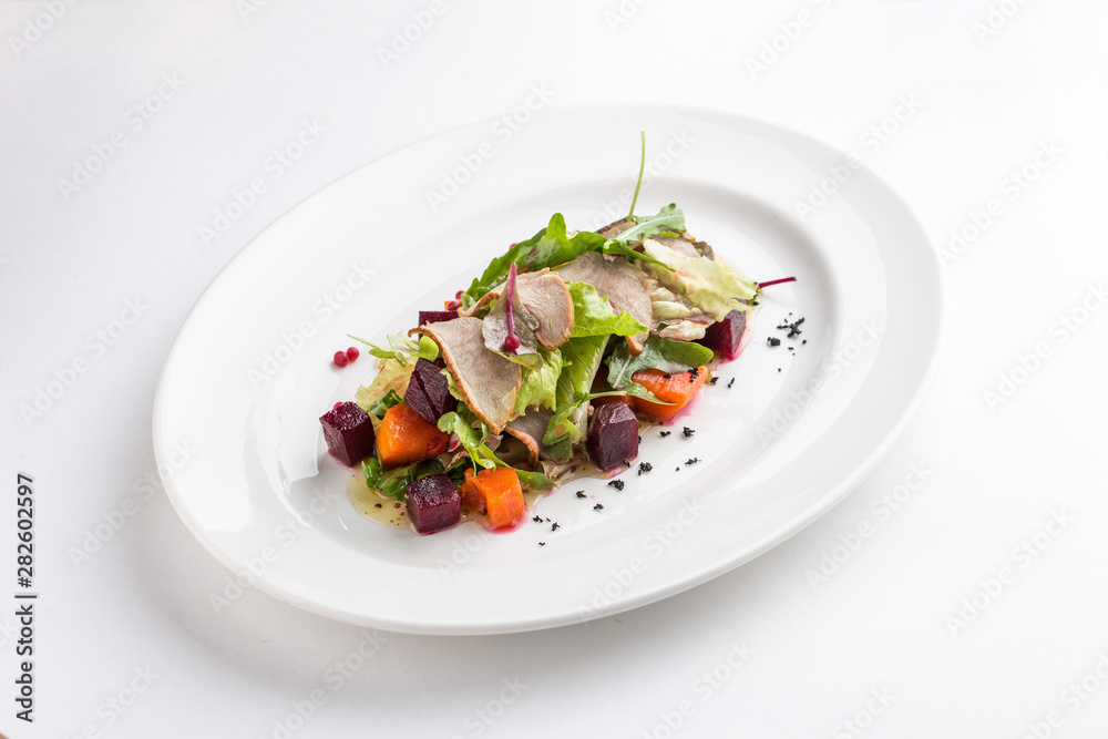 Salad with duck, spicy pumpkin and beetroot isolated on white background