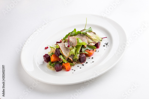 Salad with duck, spicy pumpkin and beetroot isolated on white background