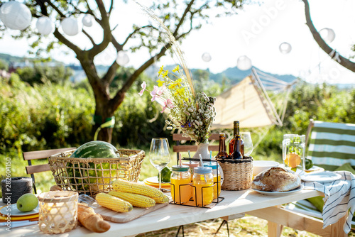 Fototapeta Naklejka Na Ścianę i Meble -  Beautifully decorated lunch table with food, drinks and flowers in the garden