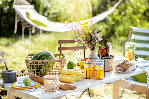 Fototapeta Naklejka Na Ścianę i Meble -  Beautifully decorated lunch table with food, drinks and flowers in the garden