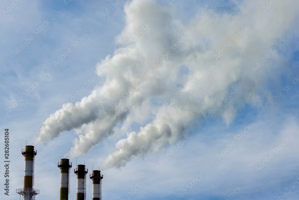 Industrial pipes release gray dirty smoke into the sky, air and environmental pollution, environmental problems. Toxic emissions