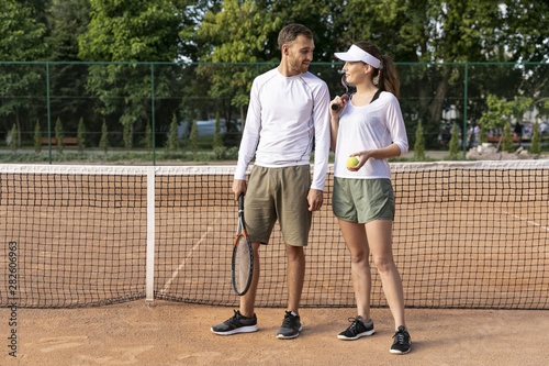 Front view couple on tennis court © Freepik