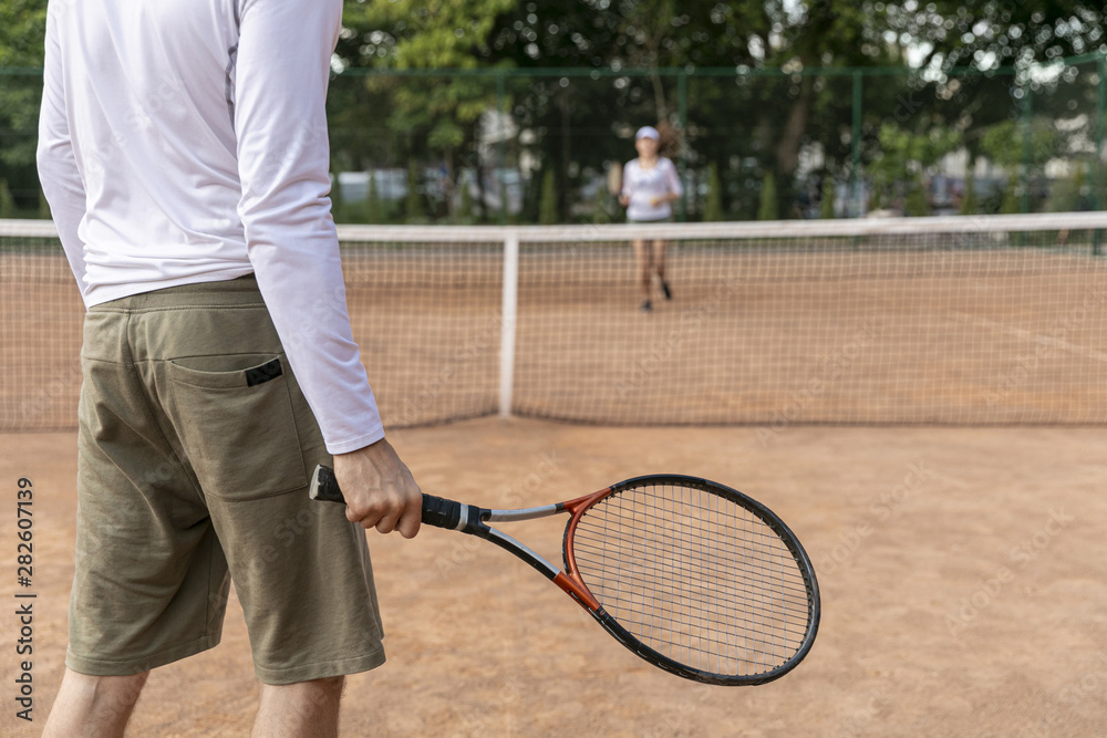 Couple playing tennis on court