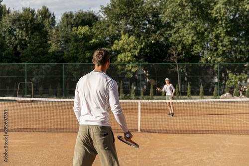 Couple playing tennis against each other