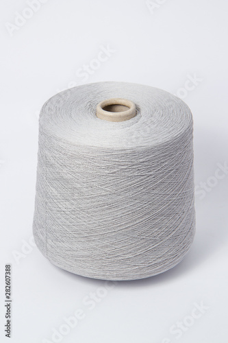 Green bobbin of yarn on a white background.Textile reel on isolated white background.