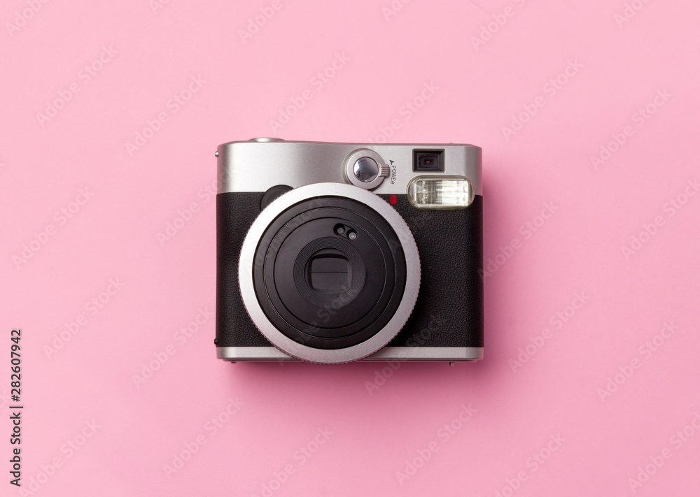 Vintage instant camera at pastel pink background.