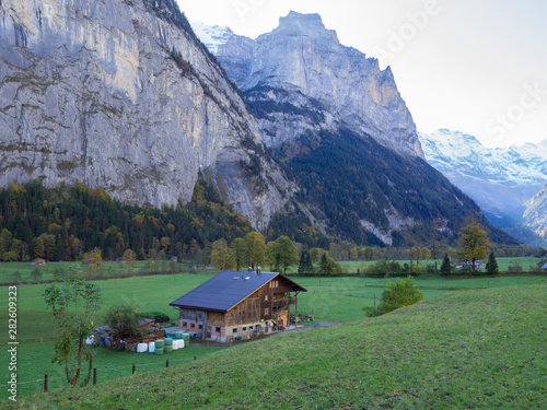 Isolated farmhouse near Tremmelbach Falls and Lauterbrunnen , Switzerland, with sheer cliffs in backgound