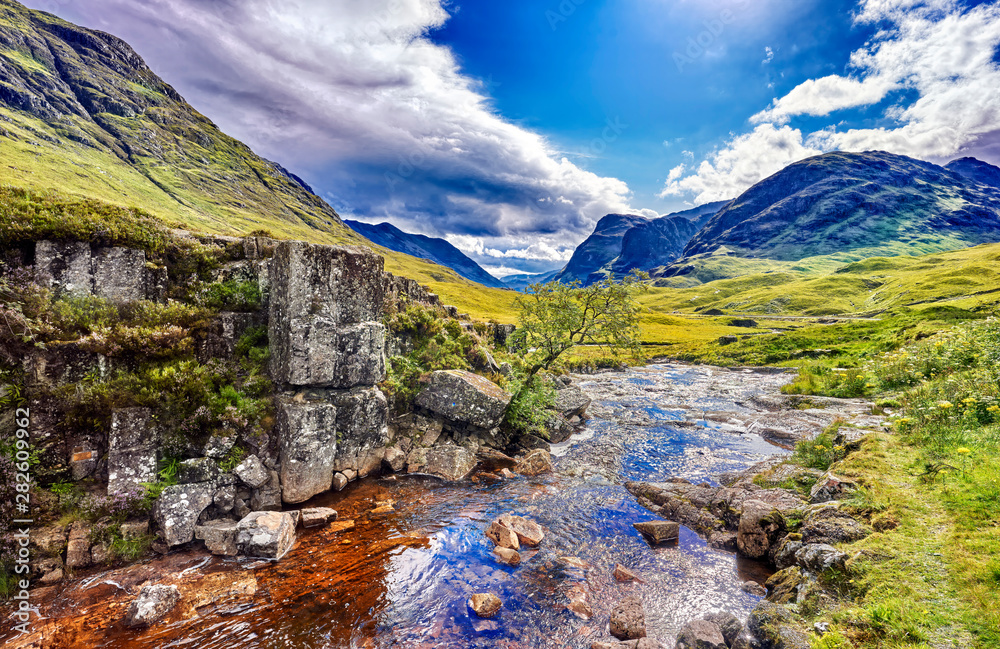 scotland, highlands with small river and blue mountains
