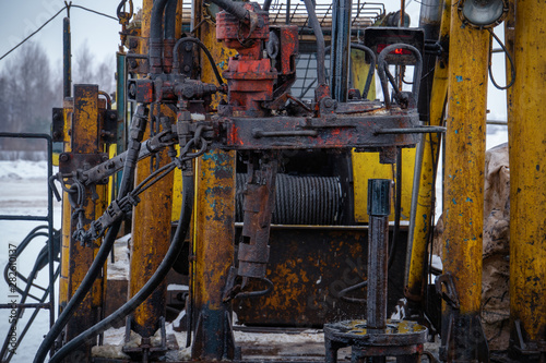 Workover rig working on a previously drilled well trying to restore production through repair. Toned.