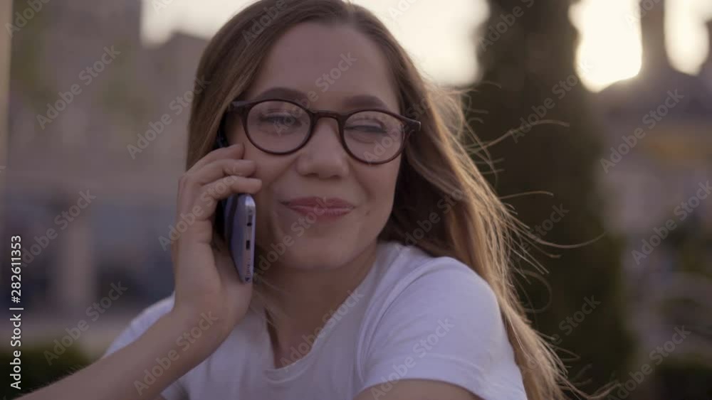 Portrait of young woman talking on her mobile phone. Outdoors. 4K Portrait of young woman talking on her mobile phone. Outdoors. 4K