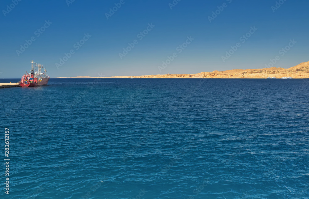 ship docked at the pier wall in port, amid open sea