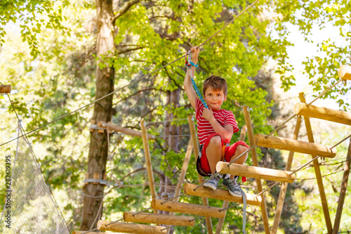 Boy portrait on sky rope suspended tree bridge