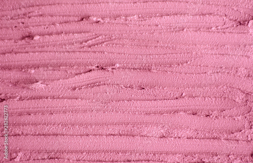 Soft pink cosmetic clay (rhassoul, facial mask, cream, scrub) texture close up, selective focus. Abstract background with brush strokes.