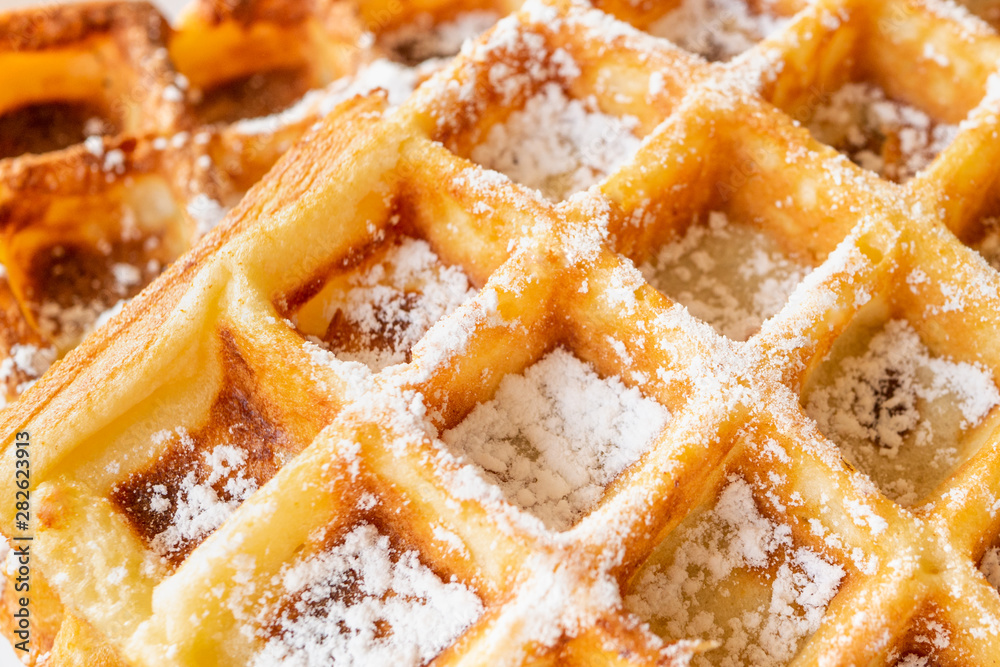 Belgian waffles sweet background with powdered sugar on top Belgian waffles sweet background with powdered sugar on top