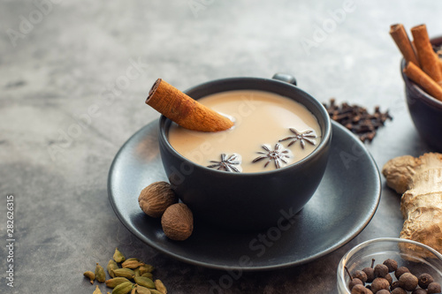 Fototapete Cup of traditional indian masala chai tea with ingredients: cinnamon, cardamom,