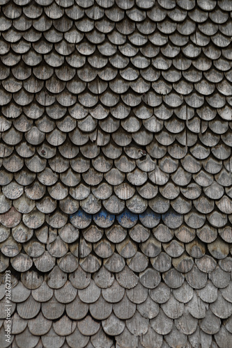 grey weathered wooden shingles on an traditional alpine roof © Marion