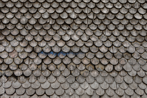 grey weathered wooden shingles on an traditional alpine roof © Marion