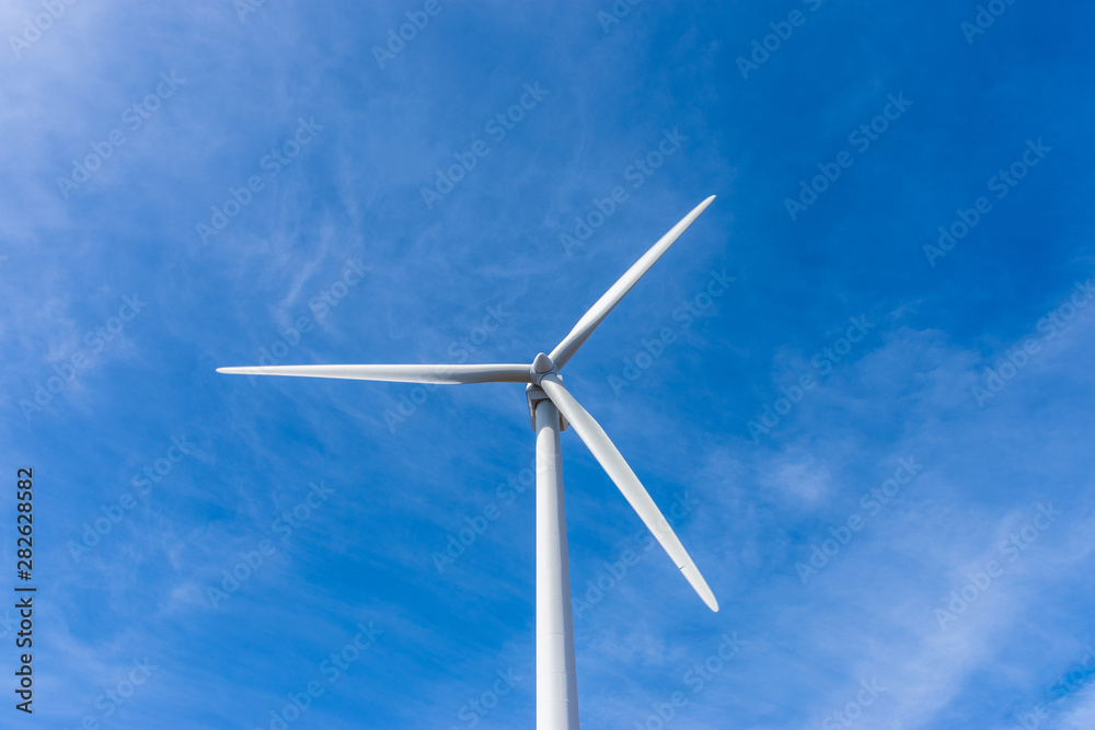wind turbine over mountains and blue sky