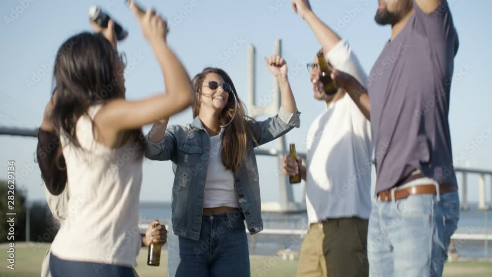 Laughing company jumping with beer bottle. Smiling young friends having fun together. Leisure concept Laughing company jumping with beer bottle. Smiling young friends having fun together. Leisure concept