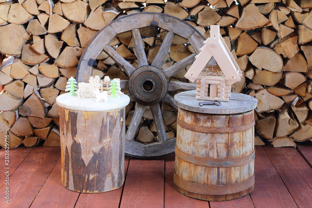 Model of a log house with iron key on a wooden tub and against the background of a stack of firewood. Real estate concept. Model of a log house with iron key on a wooden tub and against the background of a stack of firewood. Real estate concept.