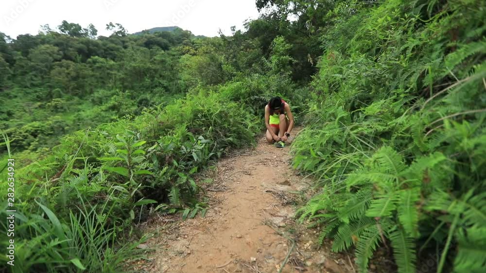 Woman ultramarathon runner running in tropical rainforest Woman ultramarathon runner running in tropical rainforest