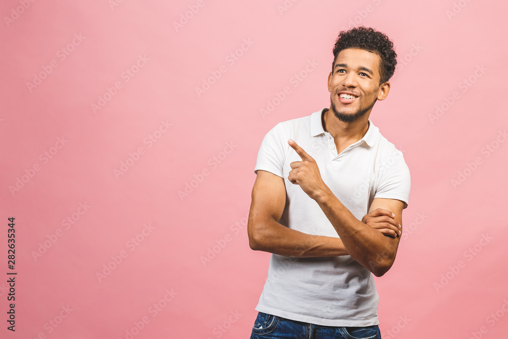 Portrait of a smiling happy african man in casual pointing with fingers aside isolated over pink background. Portrait of a smiling happy african man in casual pointing with fingers aside isolated over pink background.