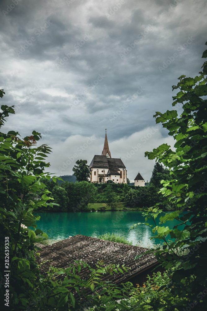 Fototapeta premium Church of Maria Worth at Lake Woerthersee near Velden in Austria during Summer