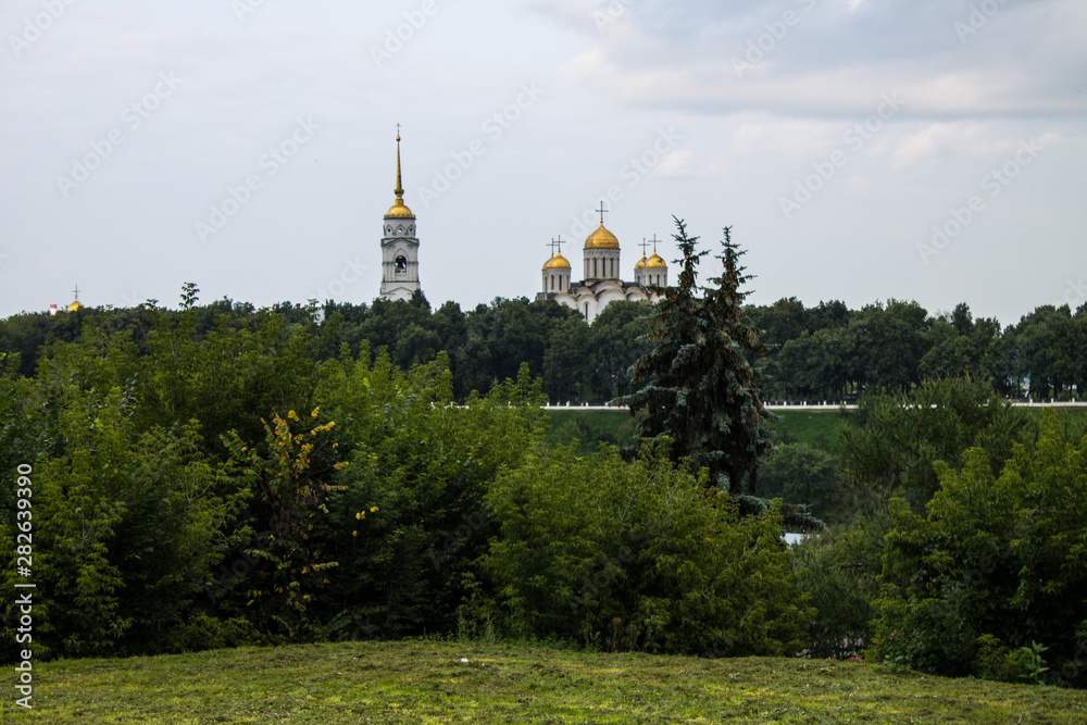 View of the Dormition Cathedral of green trees in Vladimir, Russia on a summer day View of the Dormition Cathedral of green trees in Vladimir, Russia on a summer day