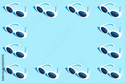 White sunglasses pattern on pastel blue background.