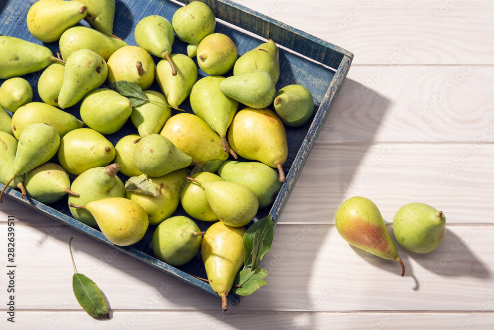 Fresh organic pears in crate on wooden table