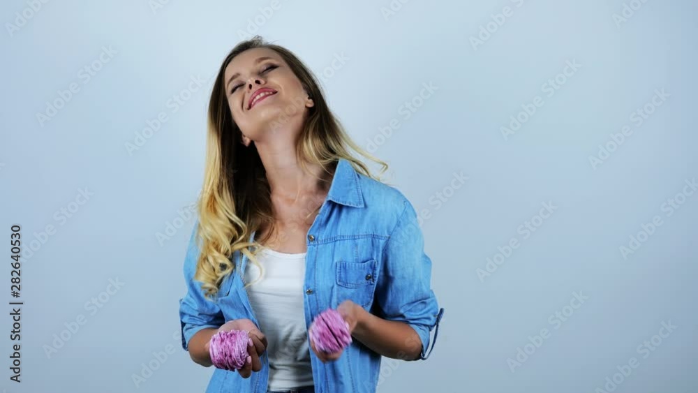 young beautiful woman smiling holding delicious cupcakes in both hands on isolated white background young beautiful woman smiling holding delicious cupcakes in both hands on isolated white background