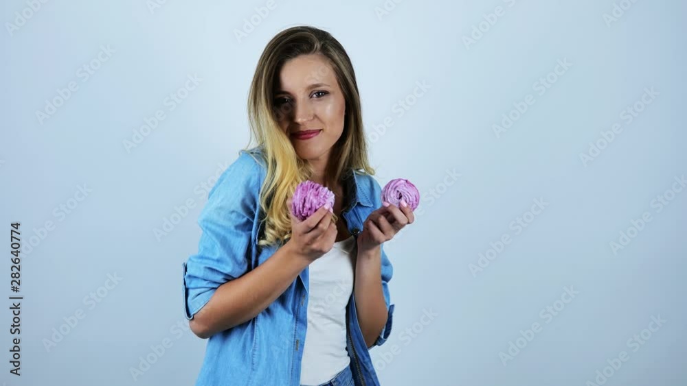 young beautiful woman smiling biting piece of delicious cupcakes on isolated white background young beautiful woman smiling biting piece of delicious cupcakes on isolated white background