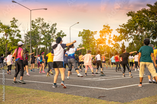 Back view of Group people workout exercise with dancing a fitness dance or aerobics in city park