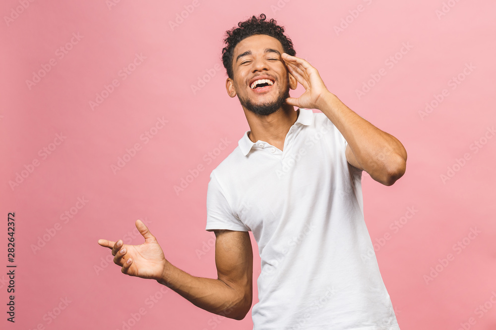 A young happy smiling funny African American male isolated against pink background. A young happy smiling funny African American male isolated against pink background.