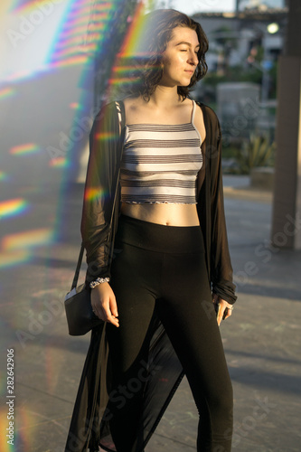 young woman facing the sun with eyes closed prism reflection