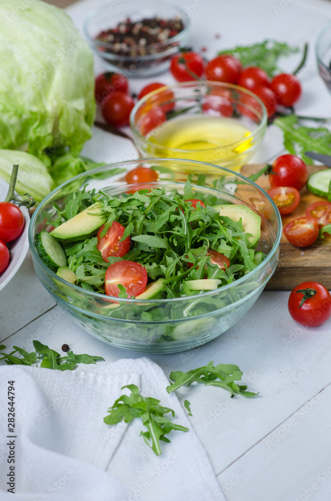 Fresh salad with cucumbers, cherry tomatoes, arugula, avocado, baby corn on white background. Vegetables on wood. Bio Healthy food, herbs and spices. Organic vegetables on wood. Fresh salad with cucumbers, cherry tomatoes, arugula, avocado, baby corn on white background. Vegetables on wood. Bio Healthy food, herbs and spices. Organic vegetables on wood.