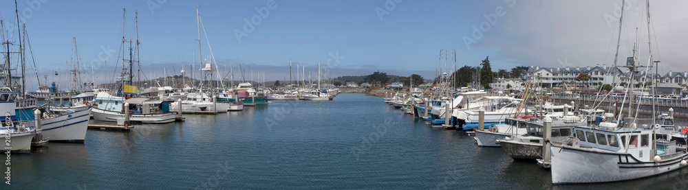 Half Moon Bay, California fishing marina with blue and foggy sky.