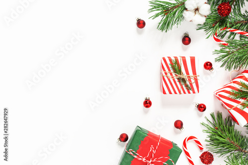 Christmas and New Year holydays composition. Fir tree branches, gifts and decor on white background. Flat lay, top view. Copy space