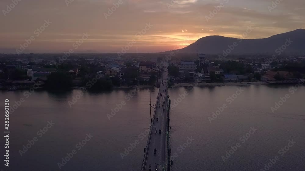 slowmotion video of motorbikes driving at sunrise over Entanou Bridge, which spans across the Praek Tuek Chhu river in Kampot, Cambodia slowmotion video of motorbikes driving at sunrise over Entanou Bridge, which spans across the Praek Tuek Chhu river in Kampot, Cambodia